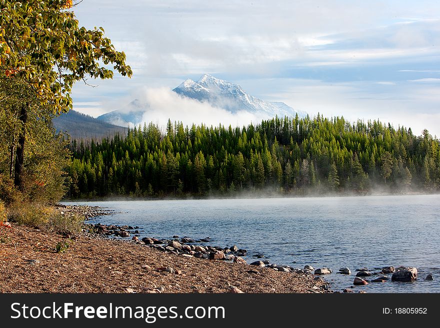 Morning steam rises off a mountain lake.