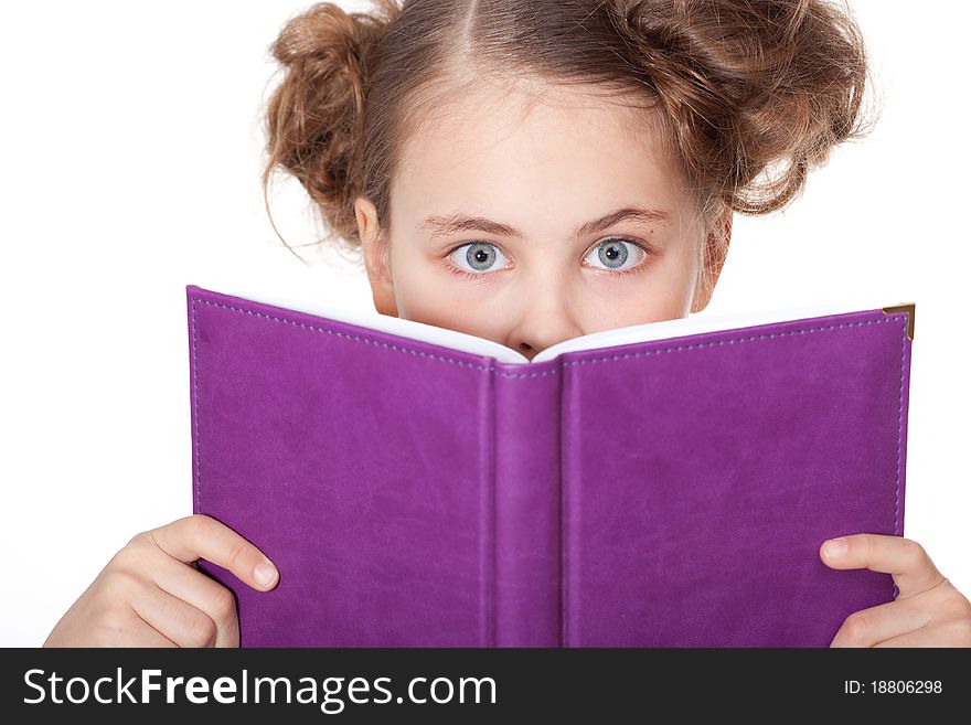Cute little girl with beautiful eyes peeping behind the book. Cute little girl with beautiful eyes peeping behind the book