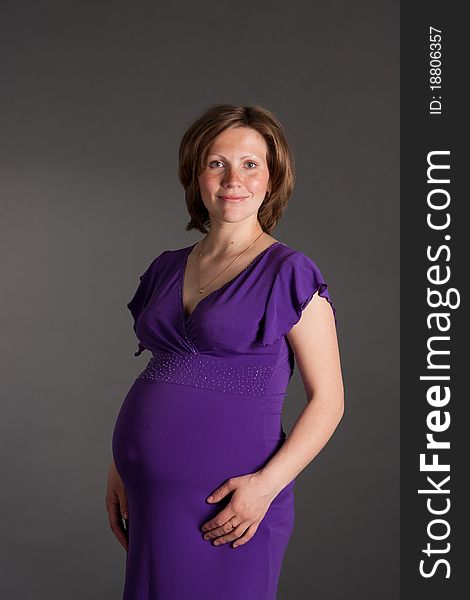 Beautiful pregnant woman staing on grey background