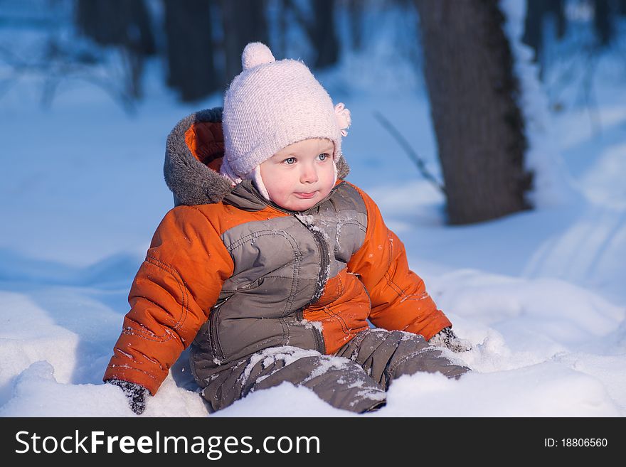 Adorable baby sit in deep snow in evening park looking forward. Adorable baby sit in deep snow in evening park looking forward