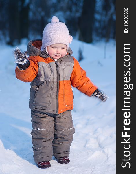 Adorable baby try to remove snow from mittens