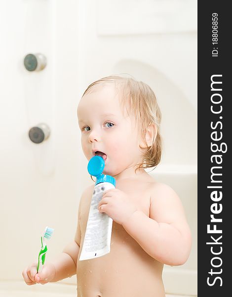 Adorable baby brushing teeth in shower holding tooth paste. Adorable baby brushing teeth in shower holding tooth paste