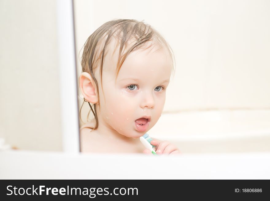 Adorable baby brushing teeth sitting in shower. Adorable baby brushing teeth sitting in shower