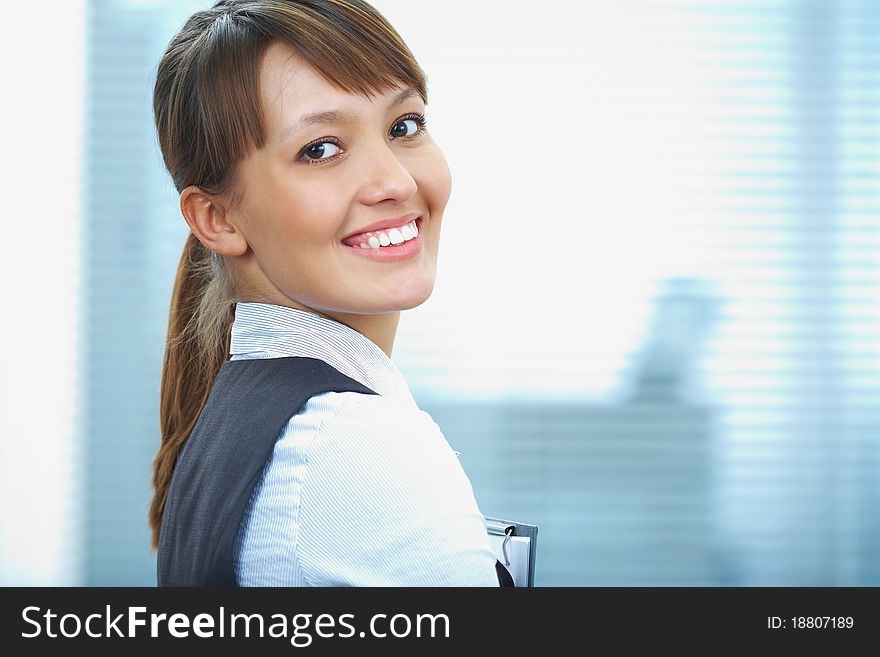 Portrait of a young businesswoman smiling against the office background