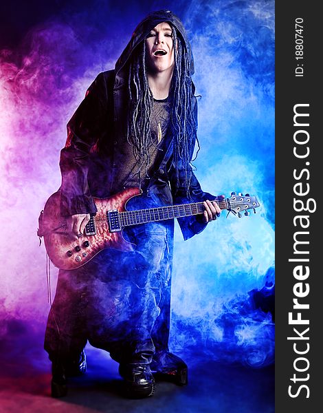 Heavy metal musician is playing electrical guitar. Shot in a studio. Heavy metal musician is playing electrical guitar. Shot in a studio.