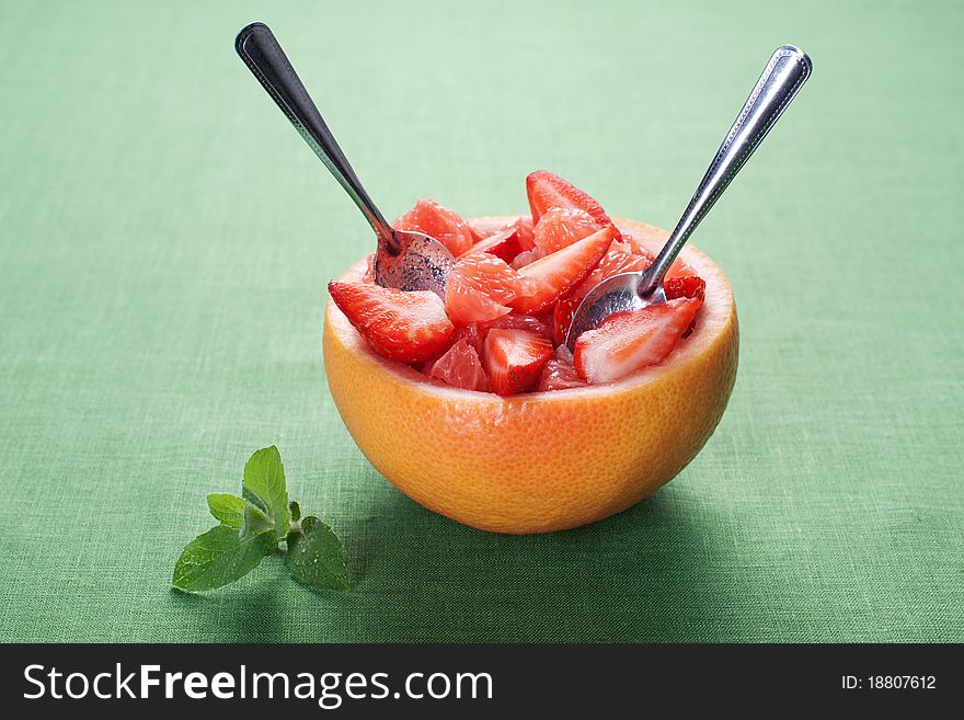 Fruit salad in hollowed-out grapefruit stuffed with strawberry. Fruit salad in hollowed-out grapefruit stuffed with strawberry