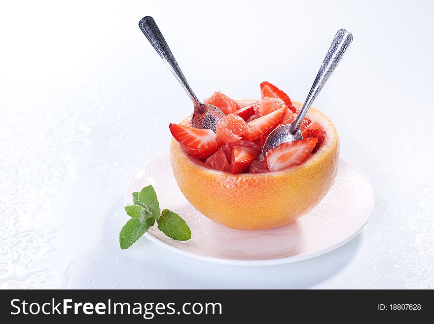 Fruit salad in hollowed-out grapefruit stuffed with strawberry. Fruit salad in hollowed-out grapefruit stuffed with strawberry