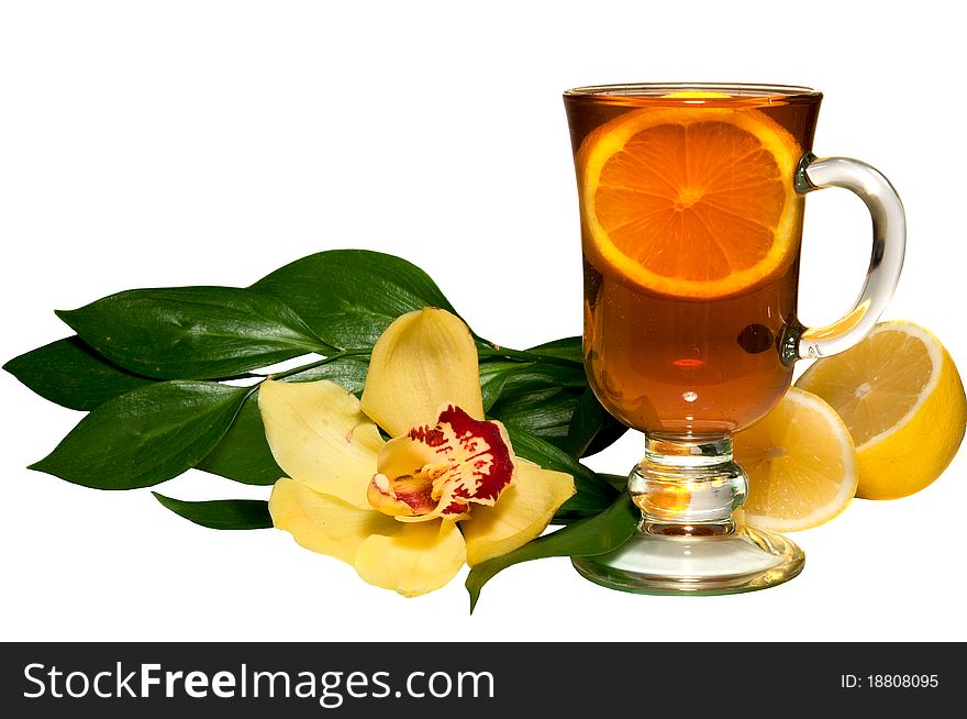 Tea in a glass glass, a lemon, flowers on the white isolated background