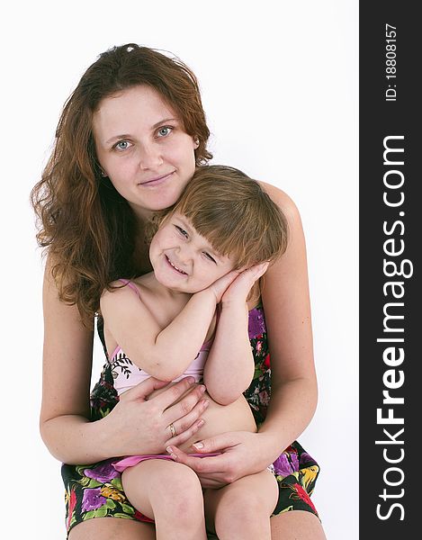 A girl sits on the lap of her mother.