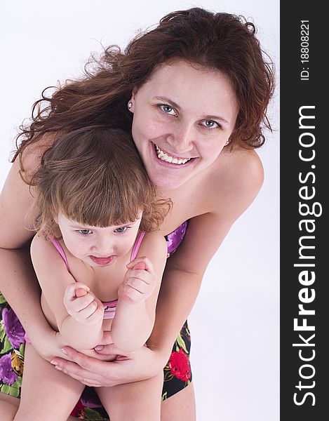 Girl sits on mother's lap. The kid shows his fists. Girl sits on mother's lap. The kid shows his fists.