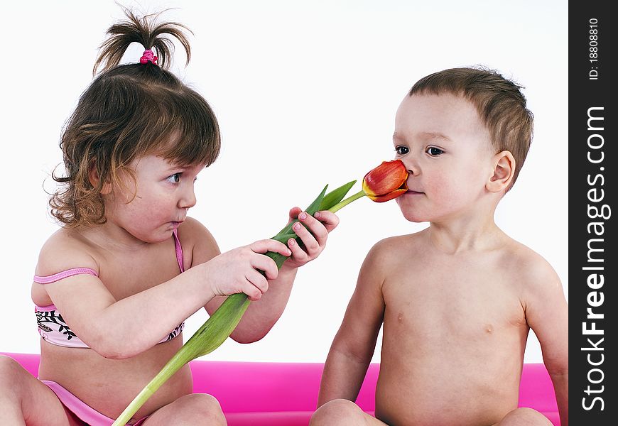 Sitting on a big air mattress.Boy wants to give a girl flowers. Sitting on a big air mattress.Boy wants to give a girl flowers