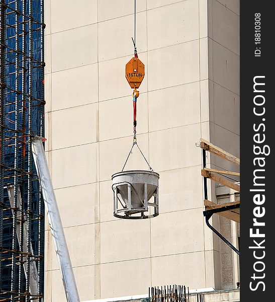 Cement bucket swinging against building. Cement bucket swinging against building