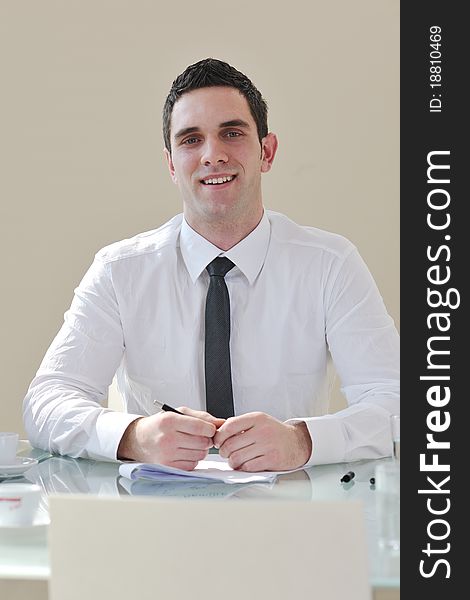 Young business man lawyer with laptop alone in big bright   conference room. Young business man lawyer with laptop alone in big bright   conference room