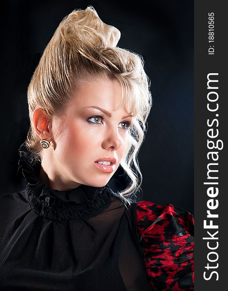 Fashion studio portrait of attractive blond young woman with makeup and coiffure on black background. Fashion studio portrait of attractive blond young woman with makeup and coiffure on black background