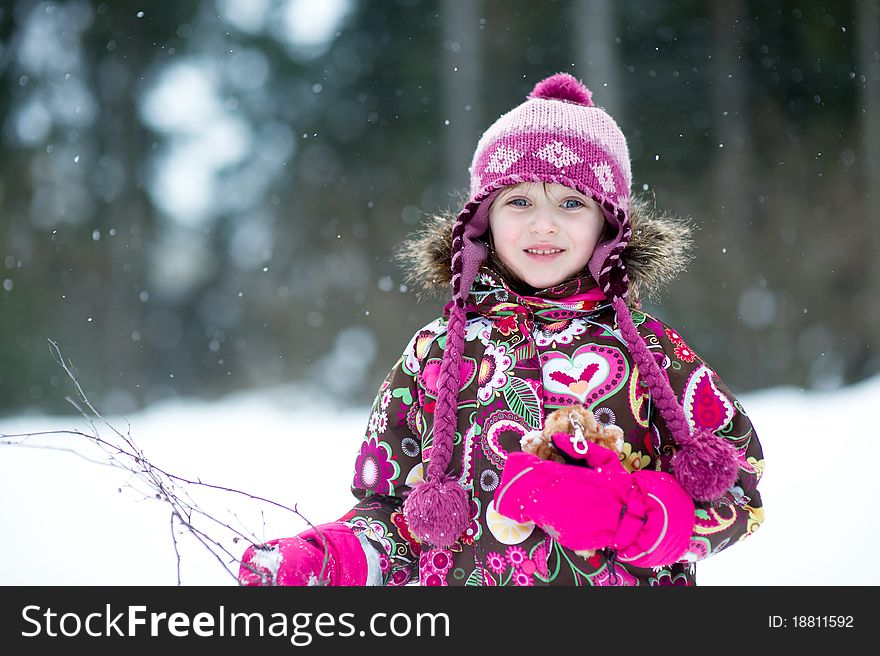 Winter portrait of beauty little girl in colorful clothes in snow