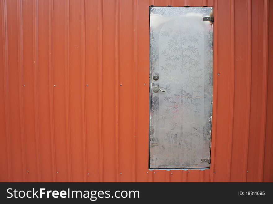 The old white steel door on the red steel wall