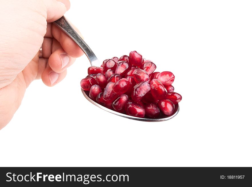 Pomegranate seeds on the spoon isolated on a white background