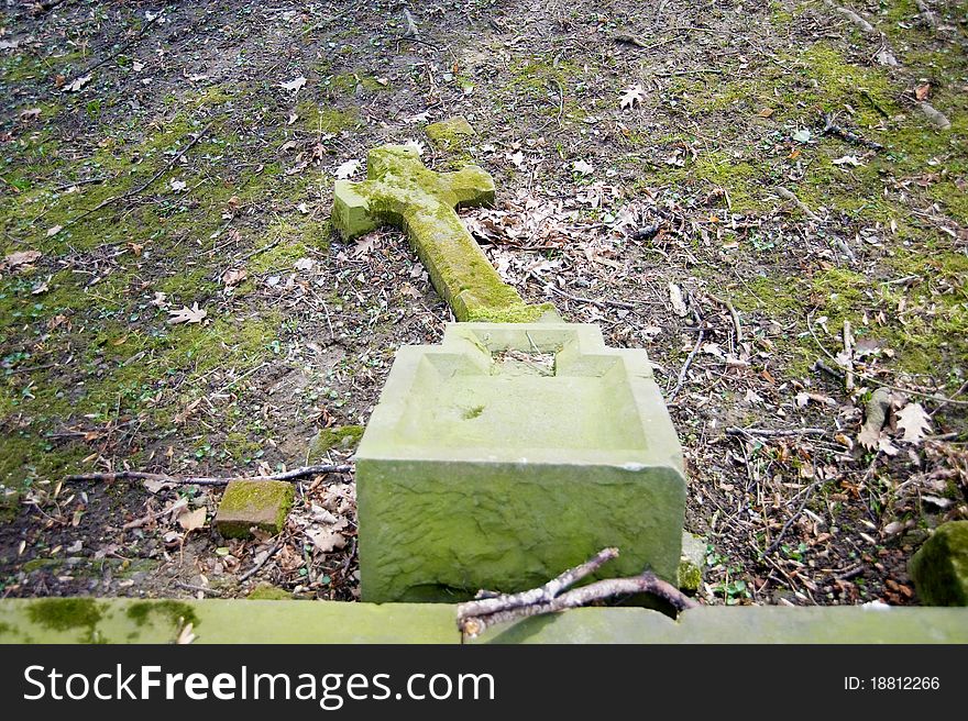 Fallen, moss cross on the cemetery. Fallen, moss cross on the cemetery