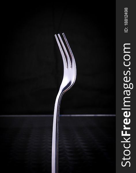 Silver fork on black background