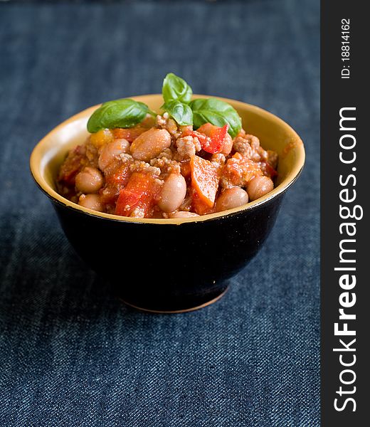 A bowl of chilli with bean and minced meat. Soft focus, shallow depth of field. A bowl of chilli with bean and minced meat. Soft focus, shallow depth of field.