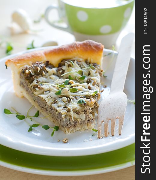 Minced meat pie with cup of chicken stock on background