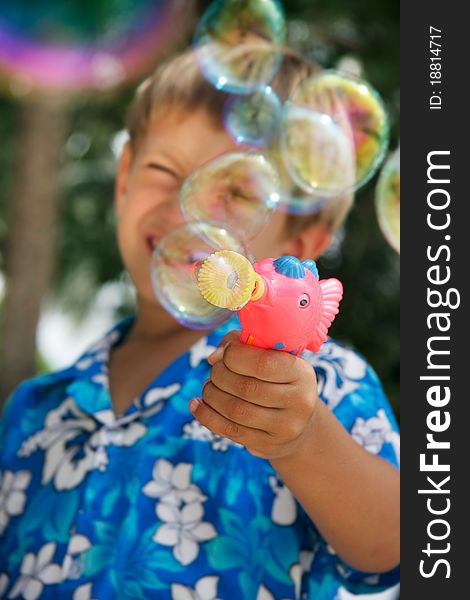 Young boy playing with bubbles on natural background