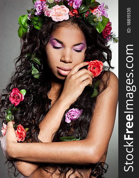 Elegant mulatto girl with circlet of flowers