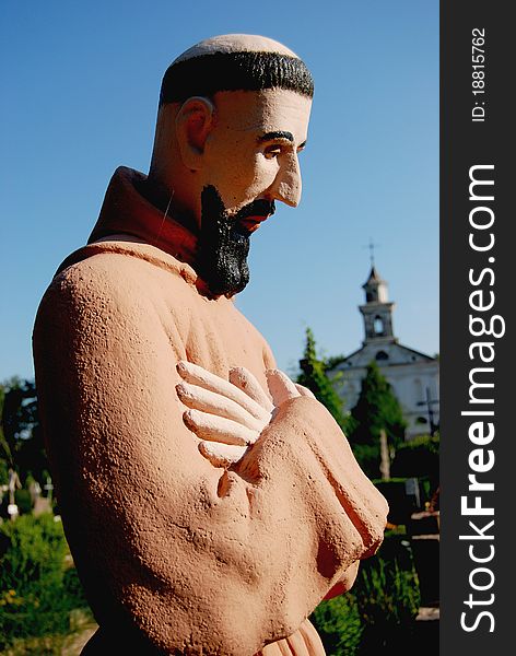 Retro monk sculpture with hands and sky background