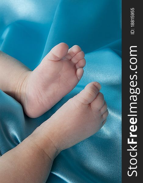 Baby feet on a blue satin background. Baby feet on a blue satin background