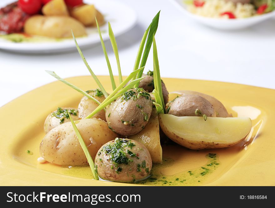 New potatoes and button mushrooms garnished with spring onion. New potatoes and button mushrooms garnished with spring onion