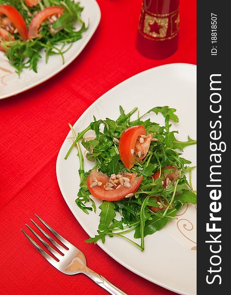 Green salad made of ruccola leaves, tomatoes and sunflower seeds. Green salad made of ruccola leaves, tomatoes and sunflower seeds