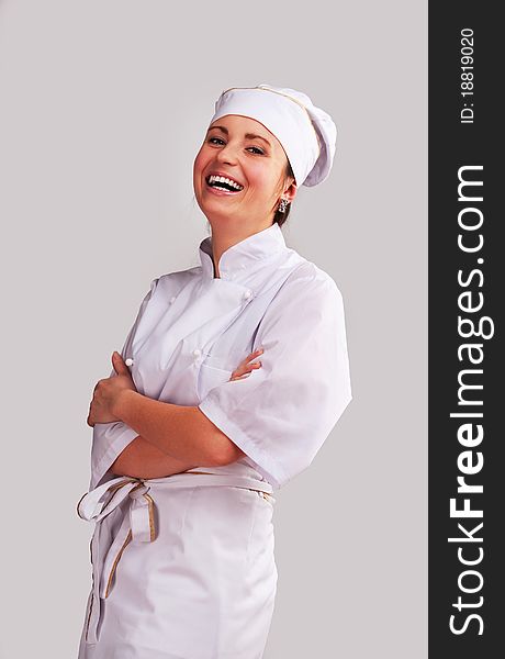 Young woman in white chef dress with hat. Young woman in white chef dress with hat