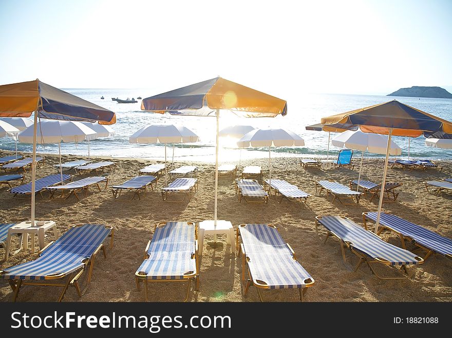 Photo free deck-chairs on seashore with water near by in summer. Photo free deck-chairs on seashore with water near by in summer