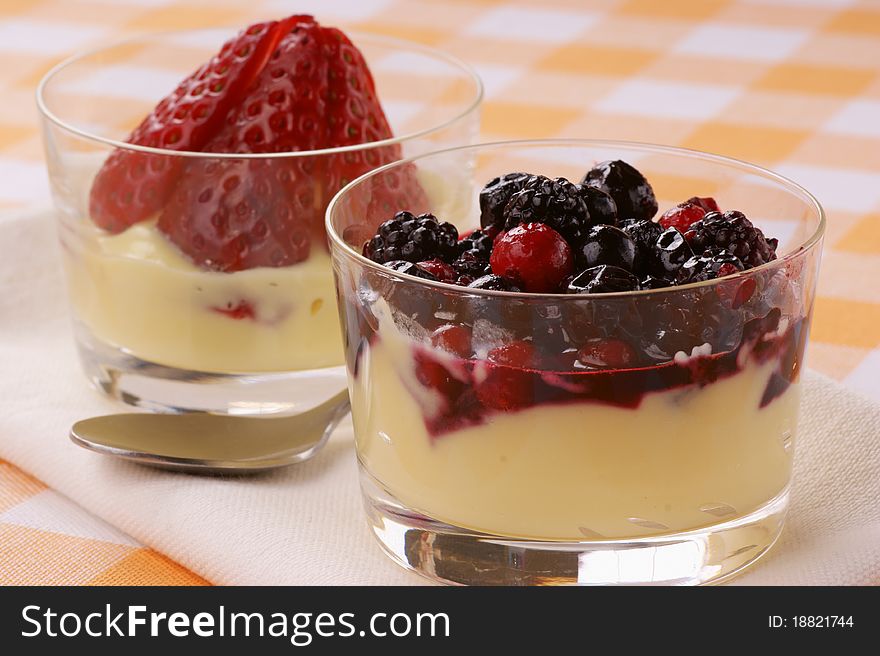 Custard with soft frutis and strawberries served in small glasses. Custard with soft frutis and strawberries served in small glasses