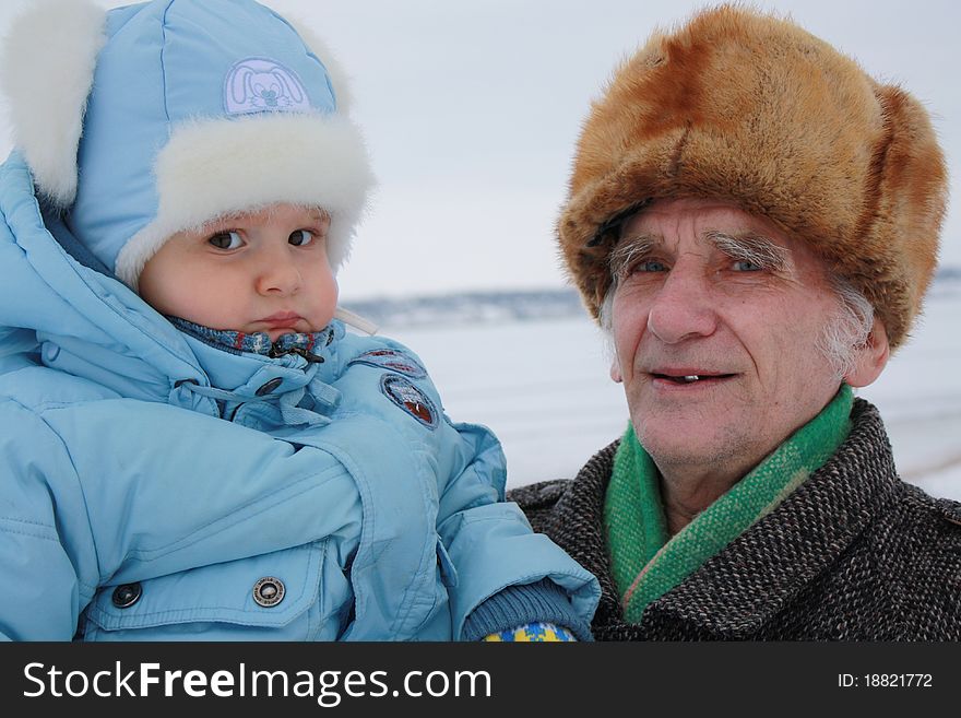 This photograph depicts a man with his great-grandson. This photograph depicts a man with his great-grandson.