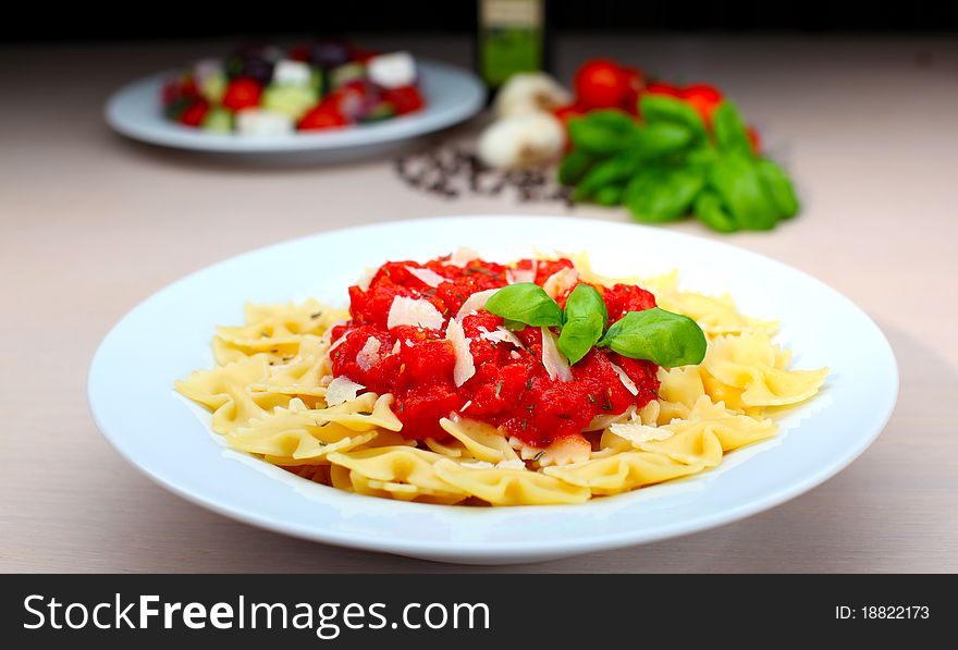 Pasta farfalle with tomato sauce and basil with salad