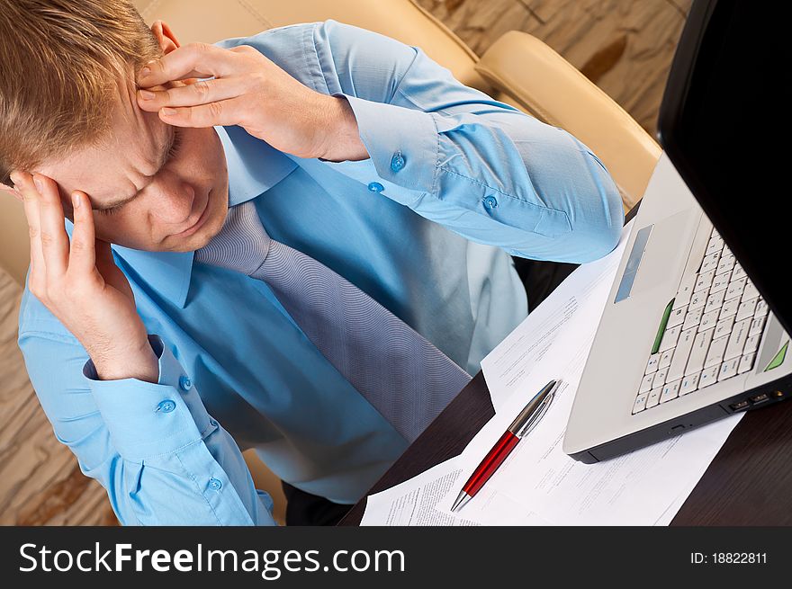 Portrait of a young businessman with headache