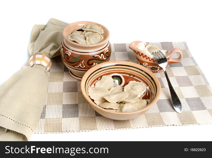 Boiled meat dumplings in ceramic bowl with fork