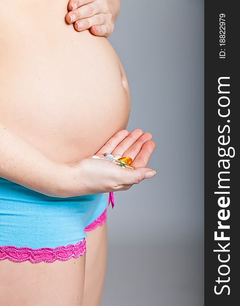 Pregnant woman holding pharmaceutical drugs