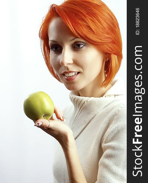 The beautiful woman with an apple in a hand on a white background