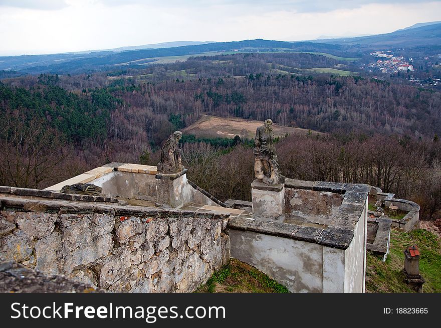 Ruined stairs with statues and European countryside during the autumn time.