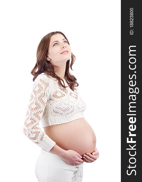 Pregnant dreamy woman holding her belly looking up