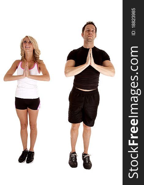 A man and woman standing side by side doing a standing yoga pose. A man and woman standing side by side doing a standing yoga pose.