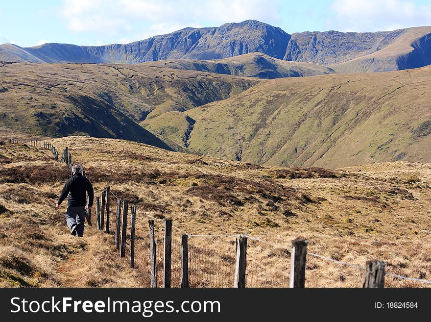 A landscape view of a walker approaching the Aran ridge in Snowdonia National Park, Wales. A landscape view of a walker approaching the Aran ridge in Snowdonia National Park, Wales