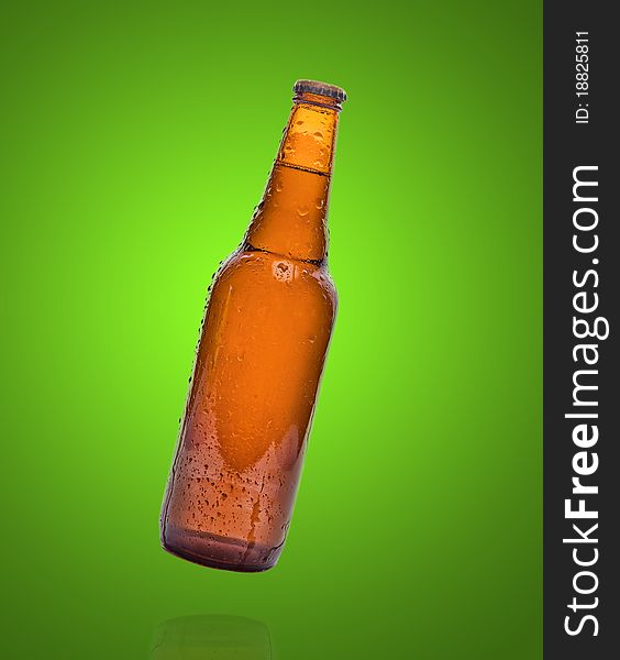 Dark bottle of beer on a green background