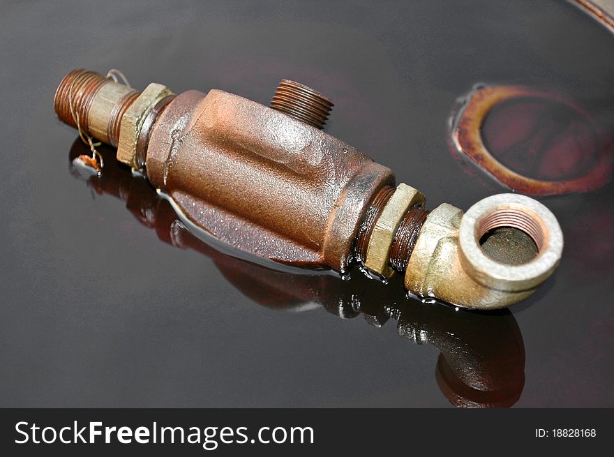 An Oil fitting on a barrel in oil