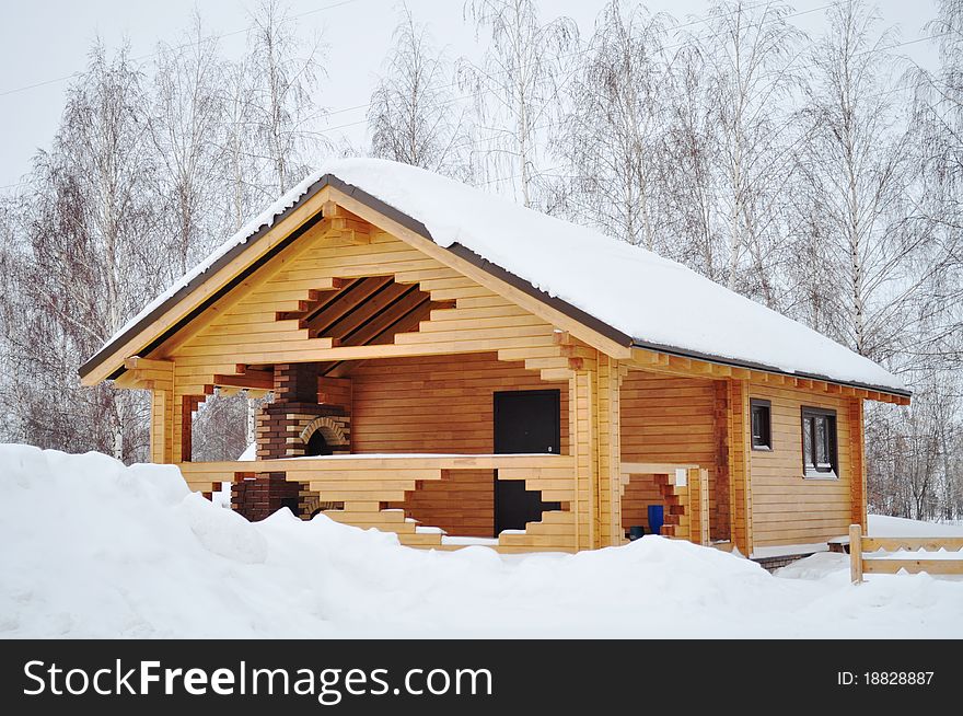 Ecological wooden house where warm even in cold, snowy winter, covered practical linseed oil, with beautiful glass windows and a fireplace in the open part of the structure. Ecological wooden house where warm even in cold, snowy winter, covered practical linseed oil, with beautiful glass windows and a fireplace in the open part of the structure