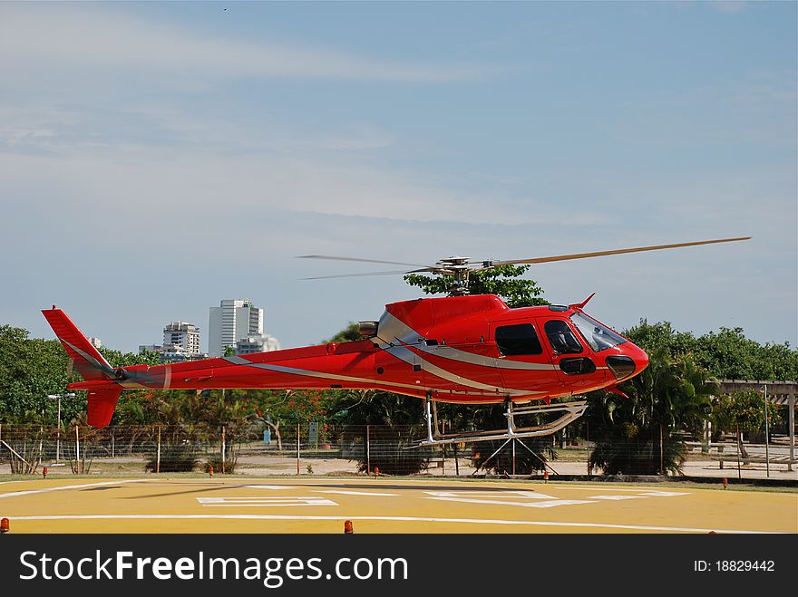 Red helicopter landing on heliport in Rio De Janeiro