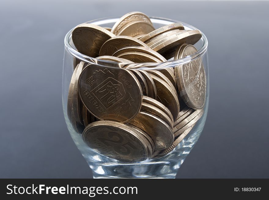 Coins in a glass on a black background