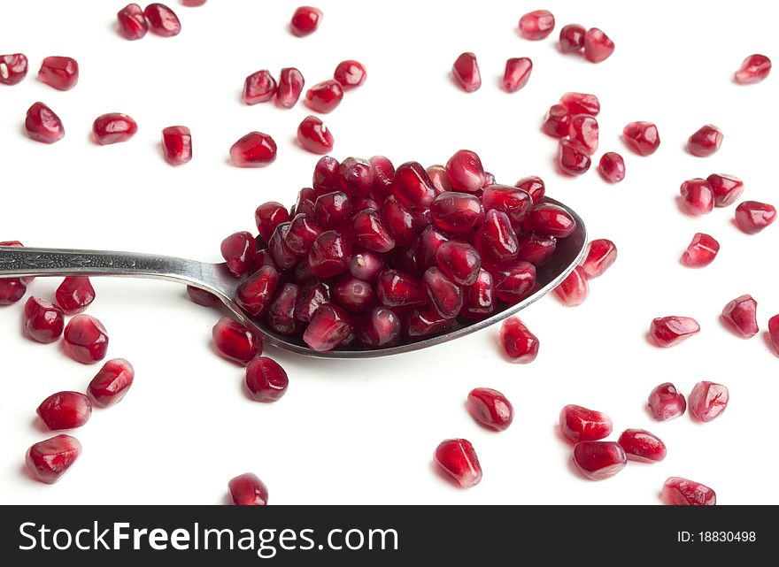 Many seeds with pomegranate on a white background